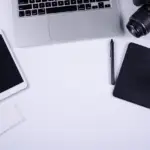 Blogger working on content audit at laptop desk with coffee