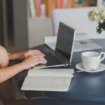 A person working on a content strategy audit with a laptop and notebook on a desk