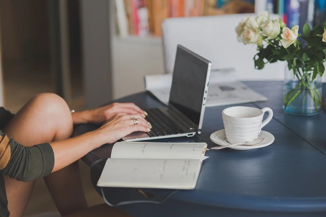 A person working on a content strategy audit with a laptop and notebook on a desk