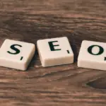Two arrows pointing in opposite directions on a wooden table, representing programmatic vs traditional SEO
