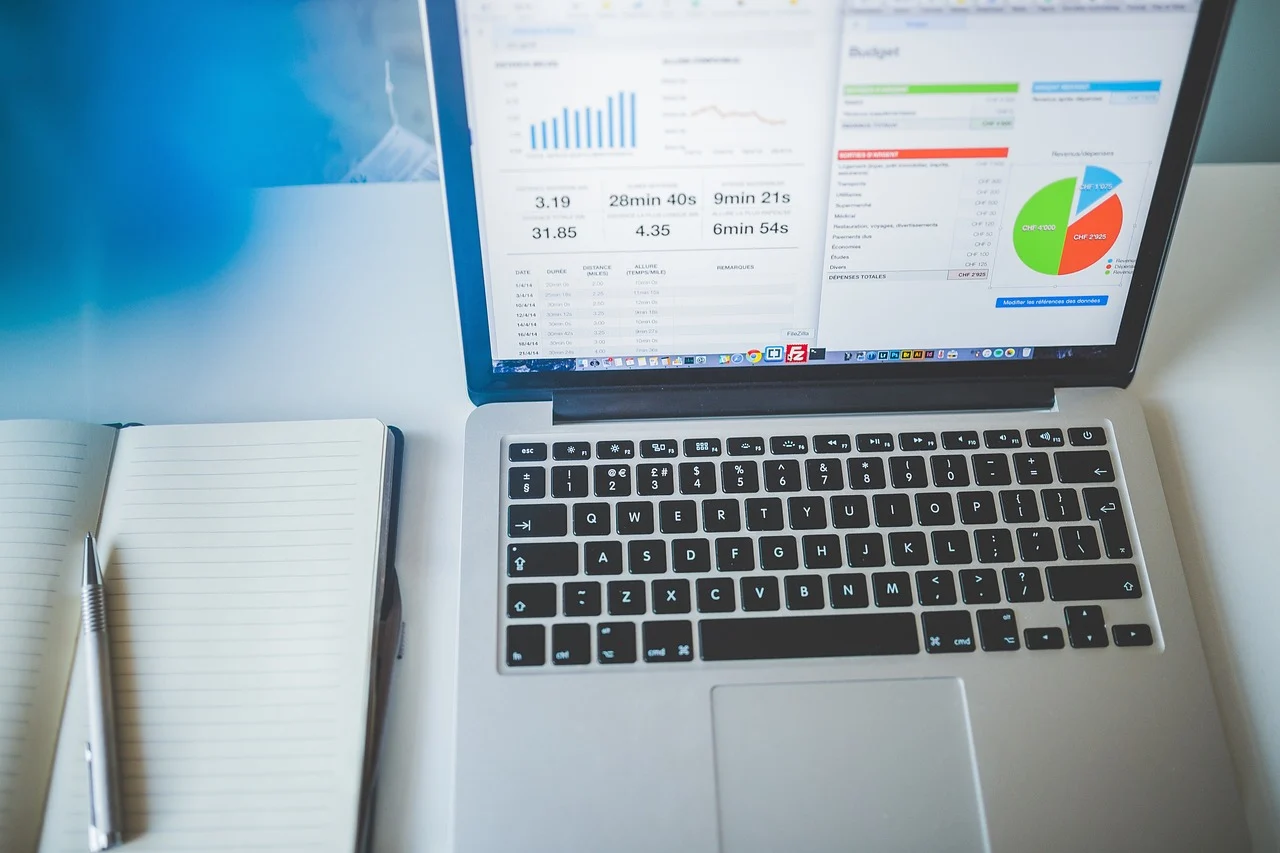 Laptop with analytics charts on desk representing niche audit data analysis