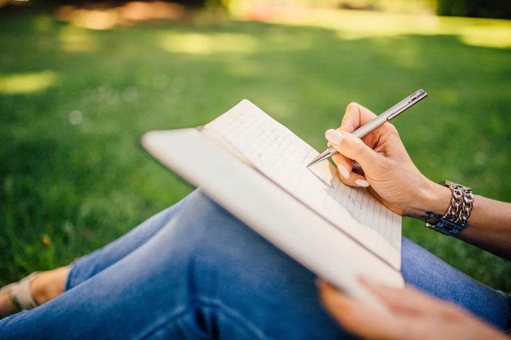 Person writing in a notebook while planning a niche audit strategy
